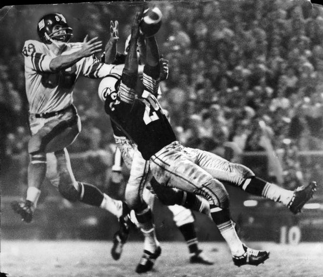 A 1969 Press Photo shows Green Bay Packer Willie Wood attempting an interception during an undated exhibition game between the Packers and Giants.