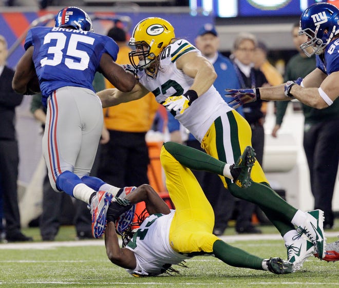 Green Bay Packers' Clay Matthews (52) misses a tackle on New York Giants running back Andre Brown (35) while M.D. Jennings trips him up during the first quarter of their game on November 17, 2013 at MetLife Stadium in East Rutherford, N.J.