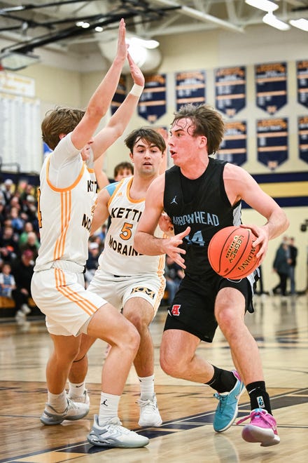 Arrowhead guard Bennett Basich  drives to the basket against Kettle Moraine forward Zach Froemming (4) and guard Jon Ksobiech (5) in a game Friday, December 8, 2023, at Kettle Moraine High School in Wales, Wisconsin. Basich scored 30 points to lead Arrowhead in a 80-59 victory.