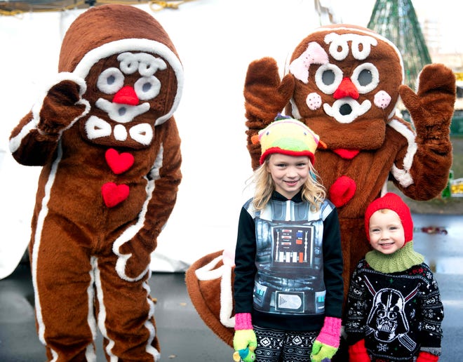 Violet Kames, 7, (left) and Celeste Kames, 3, (right) pose for a photo with gingerbread people during the Cocoa with the Clauses event in Cathedral Square Park in Milwaukee, Wis. on Saturday, Dec. 9, 2023.