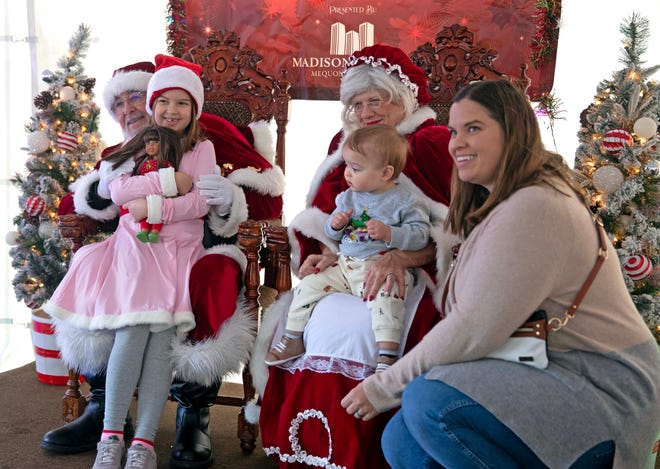 Maggie Coleman, 5, and Nathan Coleman, 1, take a photo with Santa and Mrs. Clause with their mother, Ashley Colemen, during the Cocoa with the Clauses event in Cathedral Square Park in Milwaukee, Wis. on Saturday, Dec. 9, 2023.