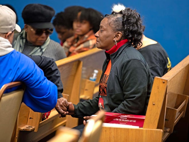 Linda Carter holds hands with a friend during a candlelit vigil honoring and remembering victims of violence in Milwaukee at House of Prayer in Milwaukee, Wis. on Saturday, Dec. 9, 2023.