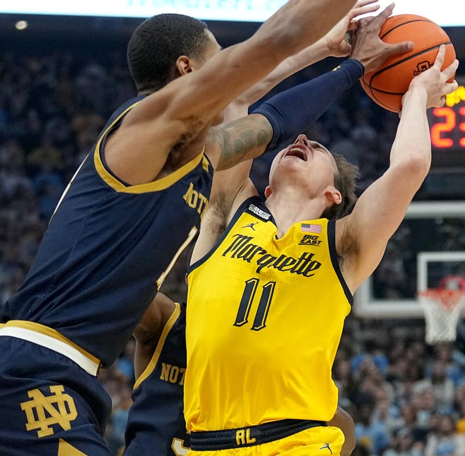 Marquette guard Tyler Kolek (11) is fouled by Notre Dame forward Tae Davis (13) during the first half of their game Saturday, December 9, 2023 at Fiserv Forum in Milwaukee, Wisconsin.